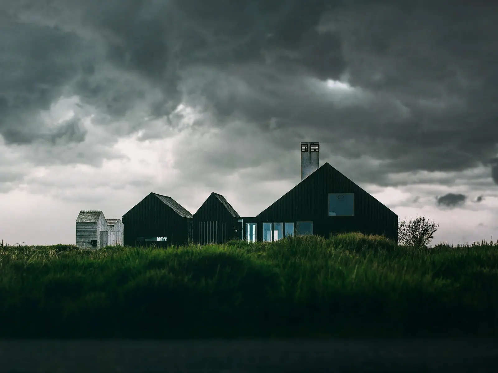 Casa de madera negra en un prado
