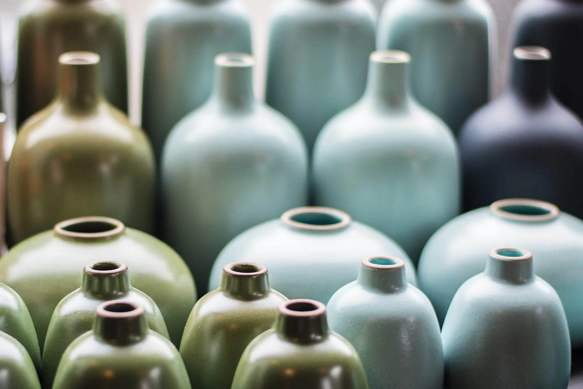 Botellas de cerámica verdes y azules en filas