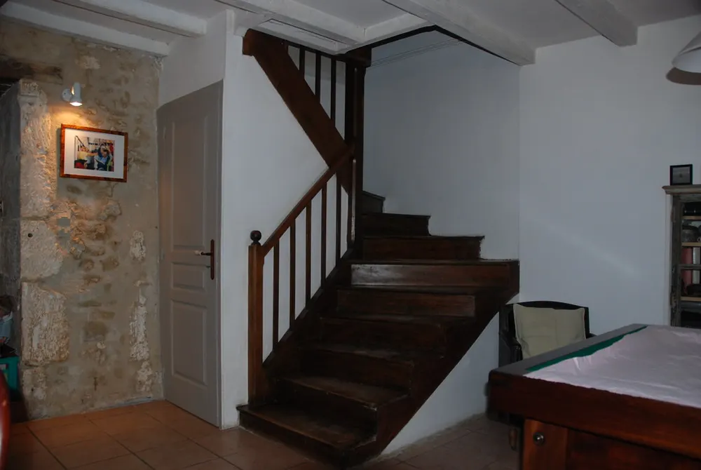 Escalera de roble oscuro de dos tramos en una casa de piedra